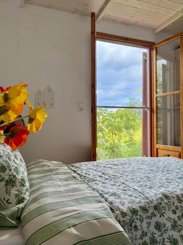 a bedroom with a bed and a window at Peaceful home amongst olive groves by the sea in Koroni