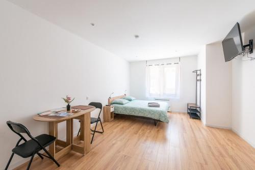 un salon avec une table et un lit dans l'établissement Résidence de l'Industrie, à Saint-Quentin