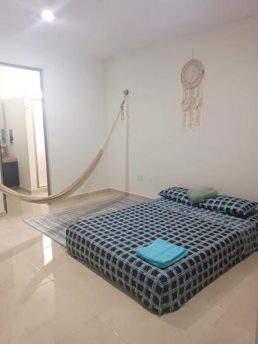 a bed in a white room with a blue pillow at Casa Goya in Mérida