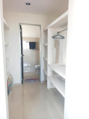 a bathroom with a closet with a toilet in it at Casa Goya in Mérida