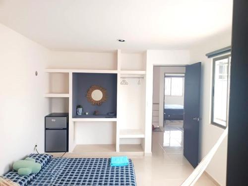 a small room with a bed and a mirror at Casa Goya in Mérida