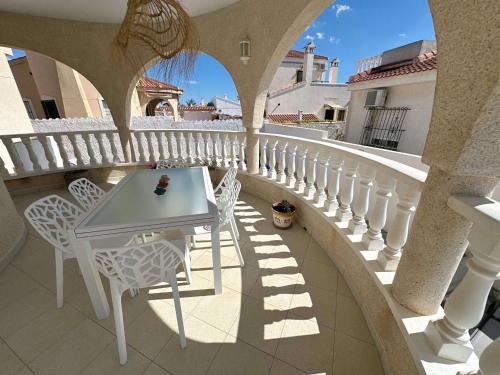 ein weißer Tisch und Stühle auf einem Balkon in der Unterkunft La Casa Nathi in Ciudad Quesada