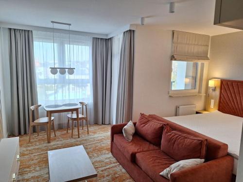 une chambre d'hôtel avec un canapé et une table dans l'établissement Apartament Amber Studio Bel Mare Aqua Resort, à Międzyzdroje