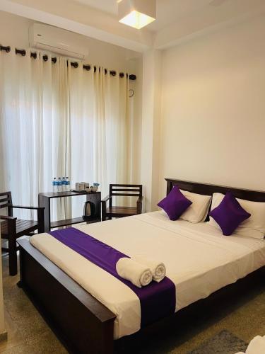 a bedroom with a large bed with purple pillows at Villa Lavish in Kandy