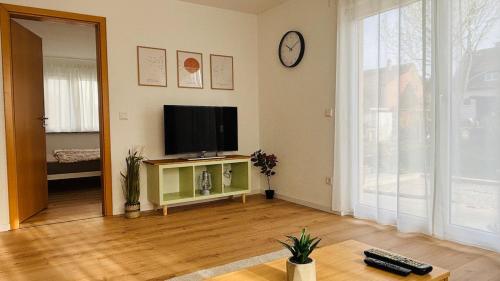 a living room with a flat screen tv on a wall at Triple-A Apartment - near Stuttgart and Karlsruhe in Mühlacker