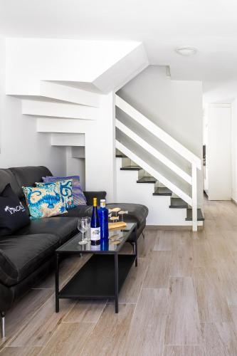 a living room with a black couch and a table at Ocean Breeze in Mogán