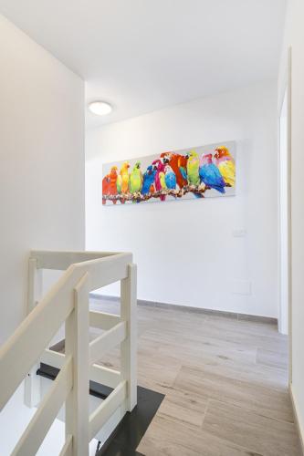 a painting of parrots on a wall in a room at Ocean Breeze in Mogán