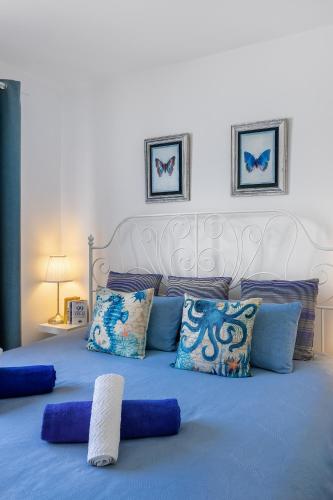a blue bed with pillows and a white headboard at Ocean Breeze in Mogán