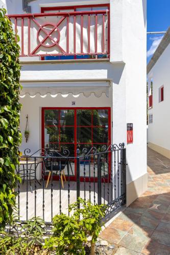 a building with a red door and a balcony at Ocean Breeze in Mogán