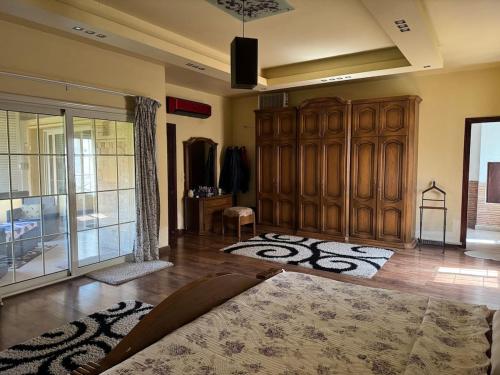 a large living room with a large wooden cabinet at Nice cozy villa in Beverly Hills quiet area in Sheikh Zayed
