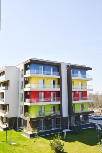 an apartment building with colorful windows and a yard at Airport Residence in Otopeni