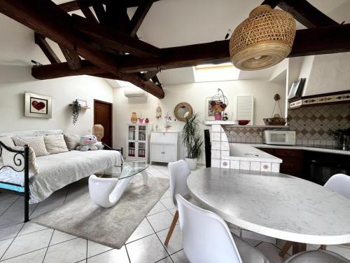 un salon avec une table et une cuisine dans l'établissement Appartement studio Le Corrandin, à Chaponost