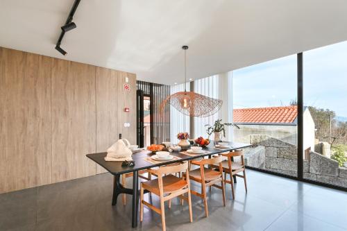 a dining room with a long table and chairs at Quinta Leitão with 25m Pool & Gim by Sé Apartamentos in Vieira do Minho