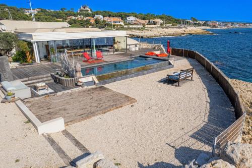 una casa con piscina junto al agua en La petite crique, en Sausset-les-Pins