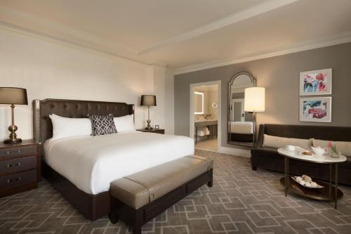 a bedroom with a large bed and a living room at Fairmont Hotel Macdonald in Edmonton