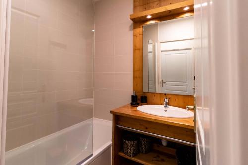 une salle de bain avec un lavabo, un miroir et une baignoire dans l'établissement Résidence Le Balcon Des Airelles - Superbe appartement au coeur des Orres 1800 MAE-1834, aux Orres