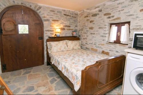 a small bedroom with a bed and a sink at Πέτρινο in Tinos