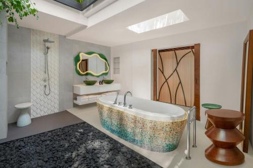 a bathroom with a large tub and a shower at W Maldives in Fesdu Island