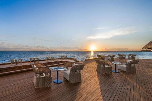 a deck of a cruise ship with tables and chairs at W Maldives in Fesdu Island