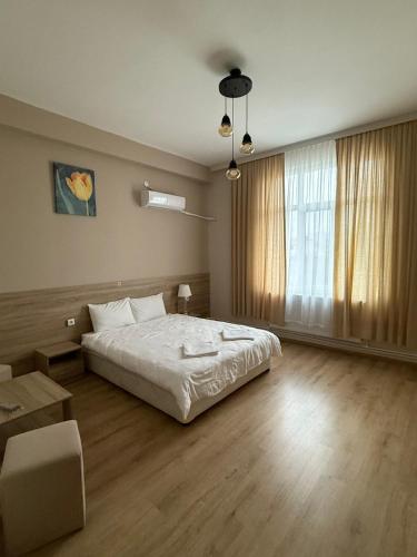 a bedroom with a bed and a large window at Hotel Tatul in Momchilgrad