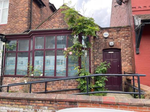 a brick house with a purple door and windows at Quirky house in Manchester