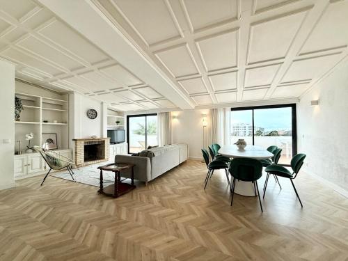 a living room with a table and chairs and a couch at Penthouse S.Jorge Seaview T4 in Quarteira