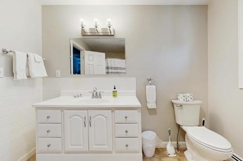 a white bathroom with a toilet and a sink at Pine Ledge in Boothbay Harbor