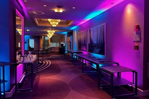 a room with purple lights on the wall and tables at Sheraton Grand Warsaw in Warsaw