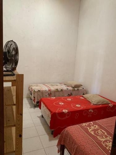 a room with three beds and a table in it at Chácara Pedacinho do Duro - Matapuã in Aracaju