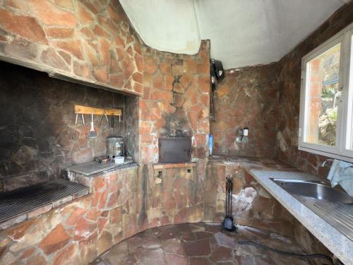 a stone kitchen with a sink and a stove at Villa Tarifa in Torrox