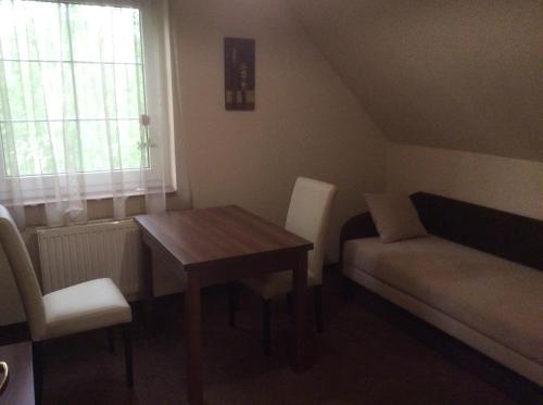 a small living room with a table and a couch at Arina Villa in Hévíz