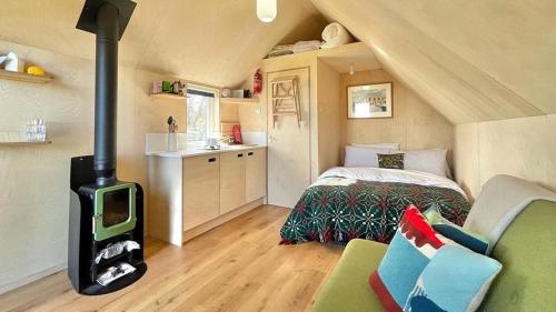 een slaapkamer met een fornuis in een kamer met een bed bij St Oswald Beach Hut Alnmouth in Alnmouth