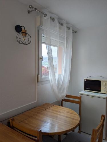 a small kitchen with a table and a window at Azur'Maline in Embrun