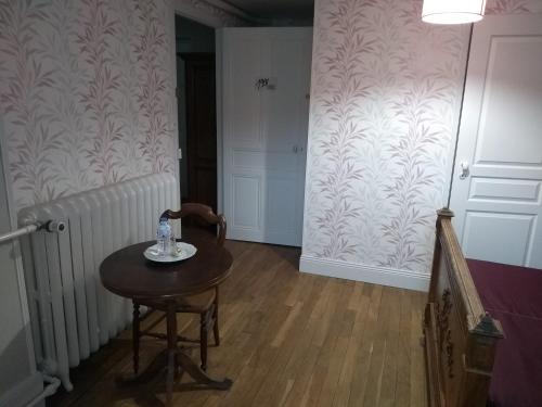 une pièce avec une petite table et un couloir avec un radiateur dans l'établissement Au Fil du Temps, à Fougerolles