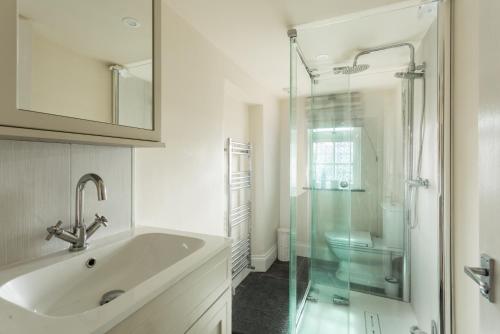 un bagno con lavandino e doccia in vetro di Crofton Dye House a Yarm