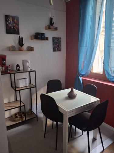 une salle à manger avec une table et des chaises et une fenêtre dans l'établissement Marrakech au centre ville, à Toulouse