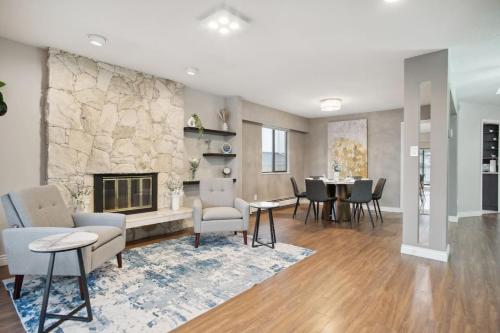 a living room with a fireplace and a table and chairs at 6 Bedroom Family Home with Indoor Arcade, BBQ, Huge Backyard & Pickleball in Vancouver