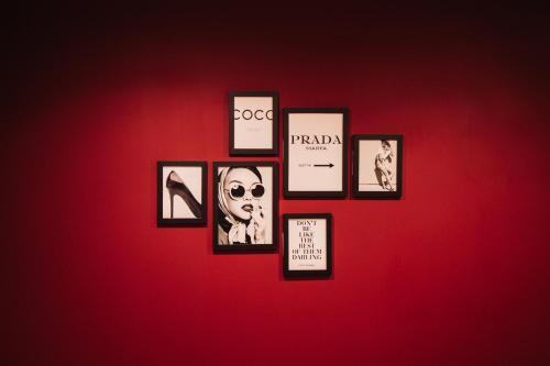 a wall with framed pictures on a red wall at Heaven Room in Striano