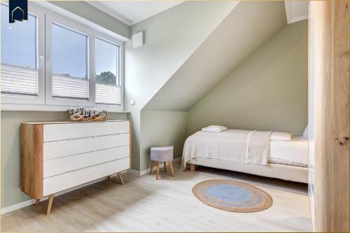 a bedroom with a bed and a dresser and windows at FeHa Windspiel in Loddin
