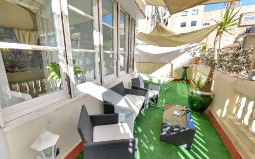 balcone con sedie, tavoli e finestre di Des Artistes a Barcellona