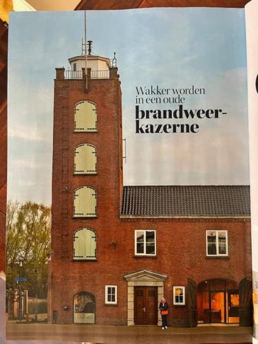 a poster of a brick building with a clock tower at De Oude Brandweerkazerne 2 tot 4 persoons 2 kamer appartement in Kaatsheuvel