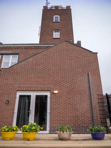 a brick building with three pots of flowers in front of it at De Oude Brandweerkazerne 2 tot 4 persoons 2 kamer appartement in Kaatsheuvel