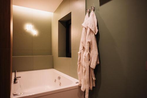 a bathroom with a tub and a towel hanging on a wall at Heaven Room in Striano