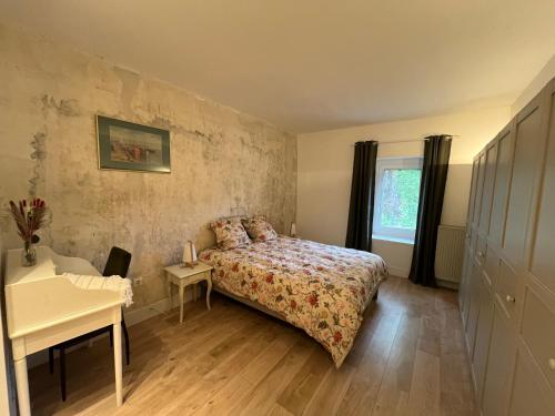 a small bedroom with a bed and a desk at Le vermeil - demeure de charme avec spa - Borne de recharge électrique in Nivolas-Vermelle
