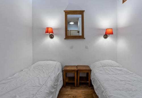 - une chambre avec 2 lits, un miroir et des lampes dans l'établissement Résidence Les Hauts De Preclaux - Studio avec vue sur les pistes MAE-9991, aux Orres