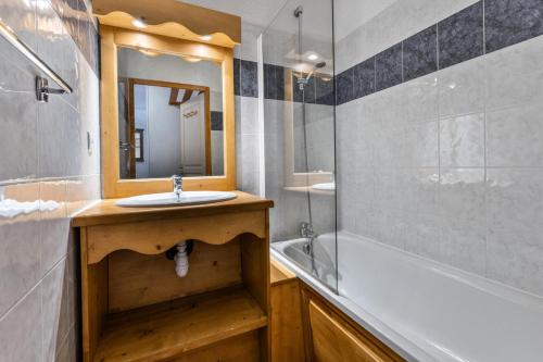une salle de bain avec un lavabo, une baignoire et un miroir dans l'établissement Résidence Les Hauts De Preclaux - Studio avec vue sur les pistes MAE-9991, aux Orres