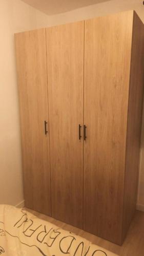 une grande armoire en bois dans une chambre avec un lit dans l'établissement Résidence Val D'aurea - Studio cabine 4 personnes 2 exposé Nord MAE-6361, à Valloire