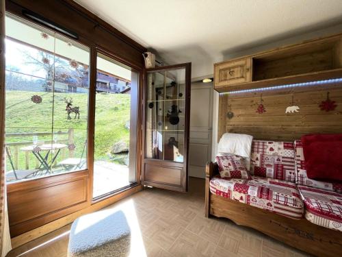 Cette chambre comprend un lit et une porte coulissante en verre. dans l'établissement Les Chalets Des Evettes - Appartement deux chambres au pied des pistes dans une résidence avec piscine MAE-9151, à Flumet