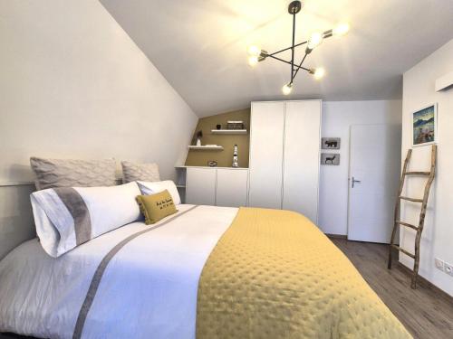 une chambre avec un grand lit avec une couverture jaune dans l'établissement Résidence Les Jardins Du Petit Port - Chic et Cosy pour ce beau 2 pièces ! MAE-6851, à Aix-les-Bains