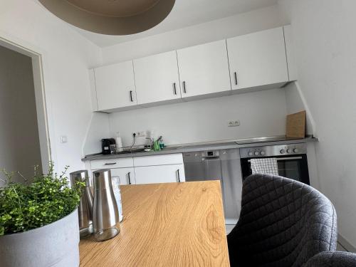 a kitchen with a wooden table and white cabinets at 2Zimmer Zentrale Lage Stellplatz Urban Light in Erlangen